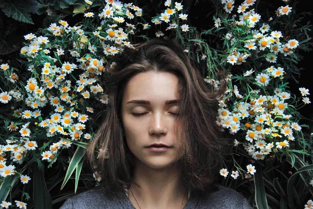 Mulher dormindo com fundo de flores em sonho lúcido